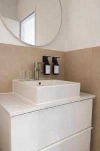 a white sink in a bathroom with a mirror at Suites in Mödling in Mödling