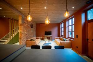 a living room with orange walls and a table and chairs at In De Rooden Hoed in Poperinge