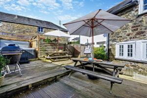 a wooden deck with a picnic table and an umbrella at 9 Bed in St. Agnes oc-port20 in St. Agnes