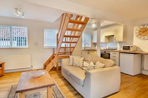 a living room with a couch and a stair case at 2 Bed in Bodham oc-m15008 in Bodham