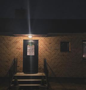 a building with a black door and a brick wall at Stora Tegelhuset in Borlänge