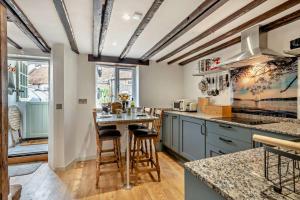 a kitchen with blue cabinets and a table with stools at 2 Bed in Bodham oc-t27775 in Bodham