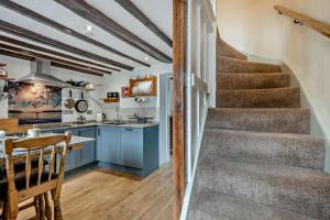 a kitchen with stairs leading up to a kitchen with blue cabinets at 2 Bed in Bodham oc-t27775 in Bodham +8 photos