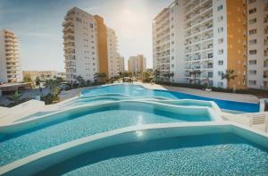 a large swimming pool with two tall buildings at Pool View Apartment with Hotel Facilities in Iskele