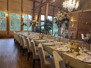 a long table with white tables and chairs in a room at Mazurski Diament koło Mrągowa in Sorkwity