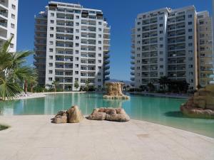 a large swimming pool with two tall buildings at Pool View Apartment with Hotel Facilities in Iskele +24 photos