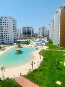 a view of a beach with palm trees and buildings at Pool View Apartment with Hotel Facilities in Iskele