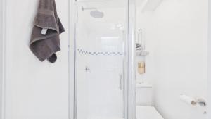 a white bathroom with a shower and a sink at 74 Granville Road in Cowes +19 photos