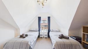 a attic room with three beds and a window at 74 Granville Road in Cowes