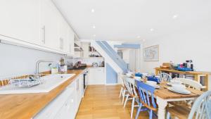 a kitchen with white cabinets and a table and chairs at 74 Granville Road in Cowes