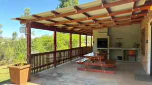 a wooden pergola on a patio with a picnic table at The Stix in Dullstroom
