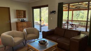 a living room with a couch and chairs and a table at The Stix in Dullstroom