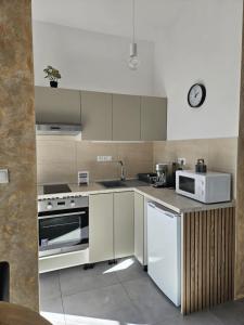 a kitchen with a stove and a microwave at Jazzy Garden Apartment Komárno in Komárno