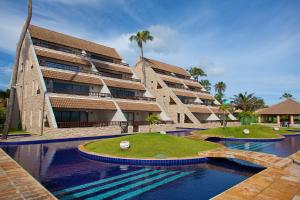 a building with a swimming pool in front of it at Cumbuco Ocean View in Cumbuco