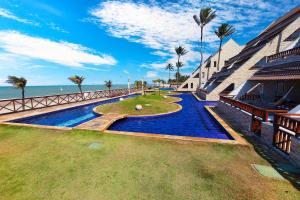 a resort with a swimming pool next to the ocean at Cumbuco Ocean View in Cumbuco