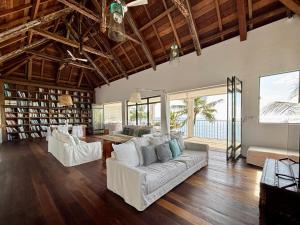 a living room with two white couches and a table at Villa Canonniers - Pieds dans l'eau à Grand Baie in Pointe aux Canonniers