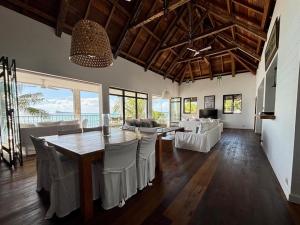 a large living room with a table and chairs at Villa Canonniers - Pieds dans l'eau à Grand Baie in Pointe aux Canonniers