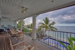 a house with a balcony with a view of the ocean at Villa Canonniers - Pieds dans l'eau à Grand Baie in Pointe aux Canonniers