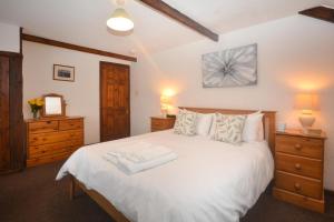 a bedroom with a large white bed with two dressers at 2 Bed in St. Merryn oc-w29716 in Saint Merryn