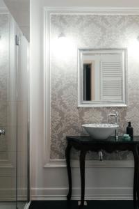 a bathroom with a sink and a mirror on a wall at Winnice Jaworek in Miękinia