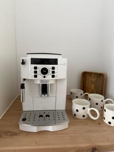 a espresso machine sitting on a wooden table with cups at R Lodge in Winterberg