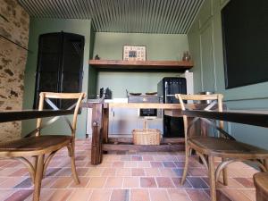 a kitchen with a wooden table and two chairs at Aumônerie du Prieuré in Pouzauges