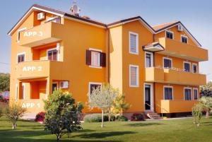 a large orange building with the names at Apartmani ANITA in Umag