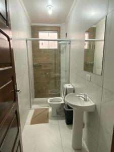 a bathroom with a toilet and a sink and a shower at Hotel Acauã in Campo Mourão +6 photos