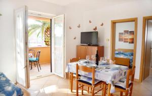 a dining room with a table and chairs and a television at Apartmani ANITA in Umag