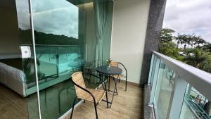 a balcony with a table and chairs and a bed at Rincão Resort in São Paulo