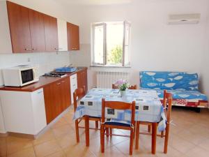 a kitchen and dining room with a table and chairs at Apartmani ANITA in Umag