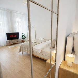 a bedroom with a bed and a mirror at Suites am Herzogberg in Brunn am Gebirge +6 photos