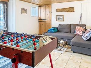 a living room with a foosball table and a couch at Apartment Les Grangettes by Interhome in Auberson