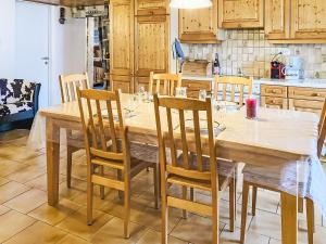 a kitchen with a wooden table and chairs at Apartment Les Grangettes by Interhome in Auberson