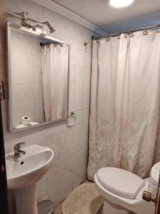 a bathroom with a toilet sink and a shower curtain at HOTEL MELLATTI in San Antonio +69 photos