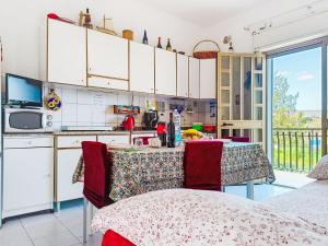 a kitchen with white cabinets and a table with chairs at Apartment Clara by Interhome in Fondachello +21 photos