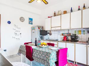 a kitchen with a table with pink chairs at Apartment Clara by Interhome in Fondachello