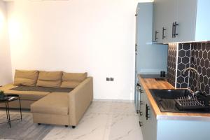 a living room with a couch and a kitchen at The Little House Lamia - Fresh Central Apartment in Lamía +14 photos