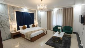 a hotel room with a bed and two green chairs at Hotel King Plaza in Nikurān +25 photos