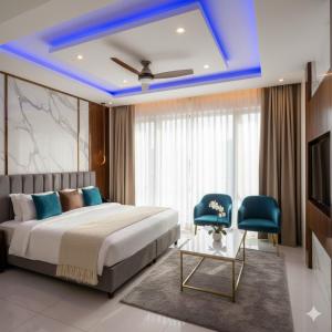 a bedroom with a bed and two blue chairs at Hotel King Plaza in Nikurān