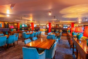 a restaurant with wooden tables and blue chairs at Fairview Caravan Hire in Lossiemouth