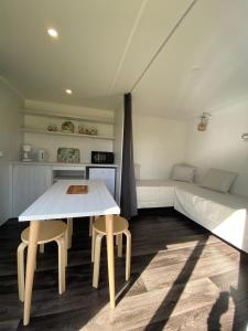 a bedroom with a bed and a table and two chairs at camping des crocs in Saint-Quentin-en-Tourmont