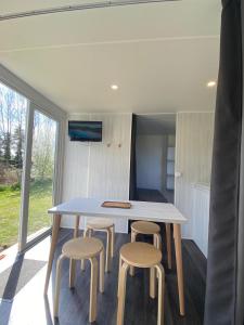 a room with a table and four stools at camping des crocs in Saint-Quentin-en-Tourmont +18 photos