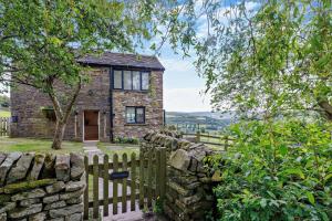 a stone house with a wooden fence in front of it at 1 Bed in New Mills oc-p29603 in Mellor