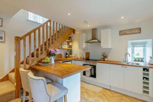 a kitchen with white cabinets and a wooden counter top at 1 Bed in New Mills oc-p29603 in Mellor