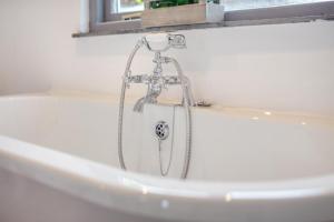 a bath tub with a shower in a bathroom at 1 Bed in Morwenstow oc-t29298 in Morwenstow +17 photos