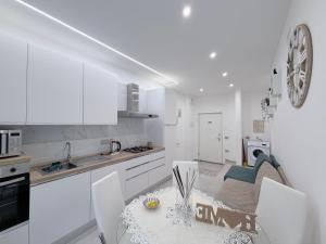 a white kitchen with a table and chairs in it at B&B Sabò in Bologna