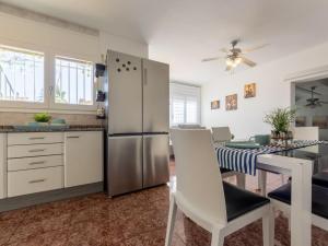 a kitchen with a stainless steel refrigerator and a table at Holiday Home Estrella by Interhome in Riumar +31 photos