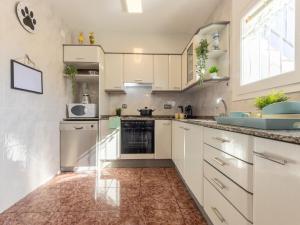 a kitchen with white cabinets and a sink at Holiday Home Estrella by Interhome in Riumar