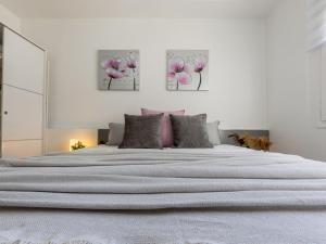 a bedroom with a large bed with pink flowers on it at Holiday Home Estrella by Interhome in Riumar